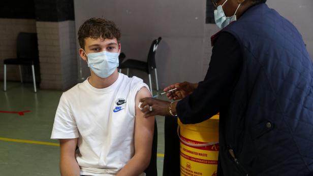 A healthcare worker administers a dose of the Pfizer coronavirus disease (COVID-19) vaccine to a teenager, amidst the spread of the SARS-CoV-2 variant Omicron, in Johannesburg