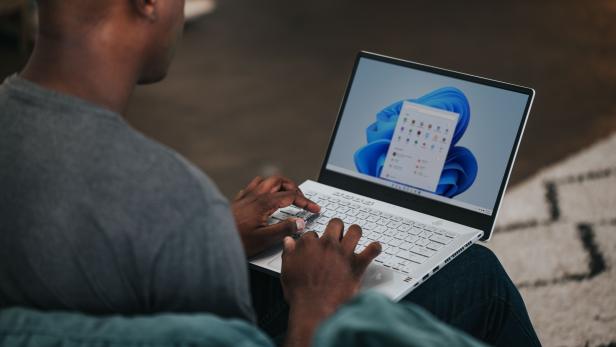 Ein Mann benutzt einen Laptop mit Windows-Betriebssystem.