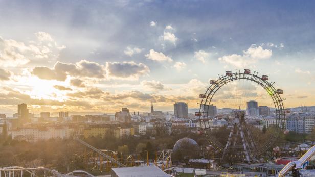 Das Wiener Riesenrad und die Skyline der Stadt bei Sonnenuntergang.