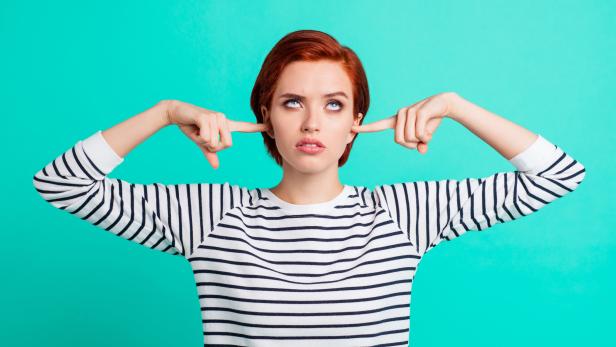 Portrait of nice pretty charming attractive sad red-haired lady wearing striped pullover rolling eyes up closing ears with forefingers isolated over bright vivid shine green turquoise background