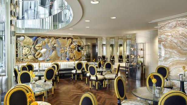 Ein elegantes Café mit Tischen und Stühlen in Gelb- und Schwarztönen.