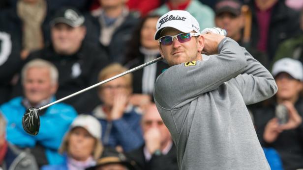 Ein Golfspieler schwingt seinen Schläger vor einer Zuschauermenge.