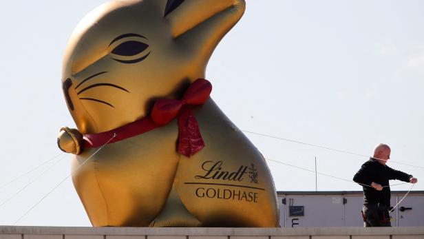 FILE PHOTO: A worker fixes a huge ballon in the shape of a famous Lindt's chocolate Easter bunny on the roof of a super market in Cologne