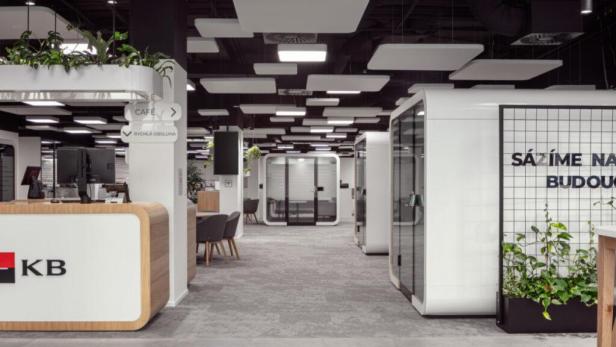 Innenansicht einer modernen KB Bankfiliale mit Schaltern und Gesprächskabinen.