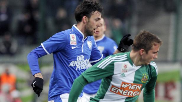 Zwei Fußballspieler im Zweikampf auf dem Spielfeld.