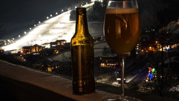 Glass and bottle with craft beer on a balcony at