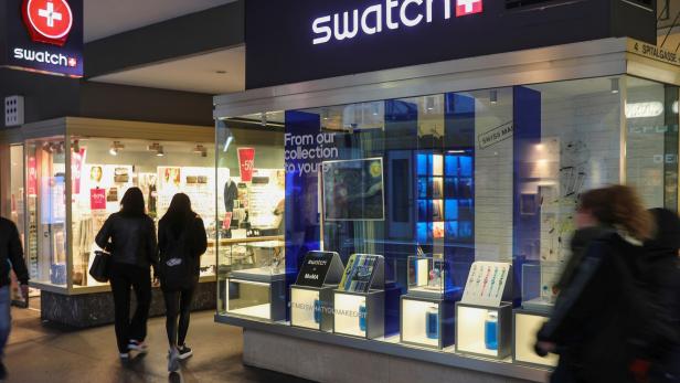 People walk past a shop of Swatch in Bern