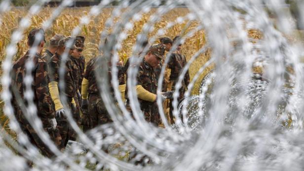 Ungarische Soldaten an der Grenze zu Slowenien entfernen den Stacheldraht wieder.