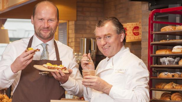 Zwei Männer präsentieren Speisen der Bäckerei Anker.