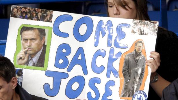 Eine junge Frau hält ein Schild mit der Aufschrift „Come Back Jose“ und Bildern von José Mourinho.