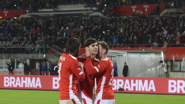 Österreichische Fußballspieler feiern gemeinsam auf dem Spielfeld.