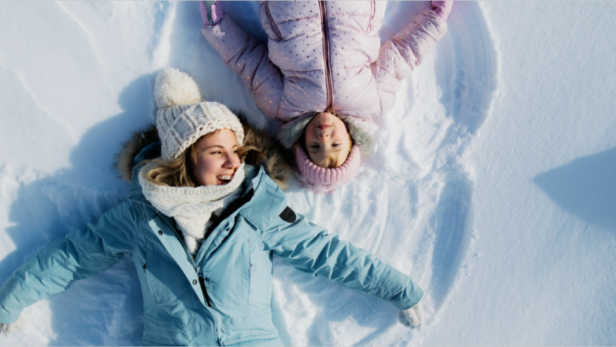 Frau und Kind liegend im Schnee