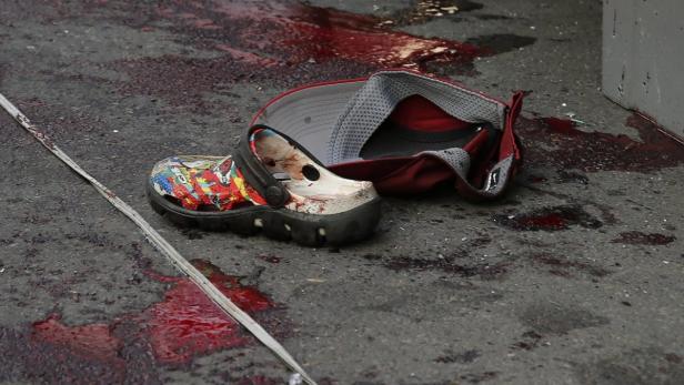 Ein verlorener Schuh und eine Kappe liegen auf dem Boden, der mit Blut befleckt ist.