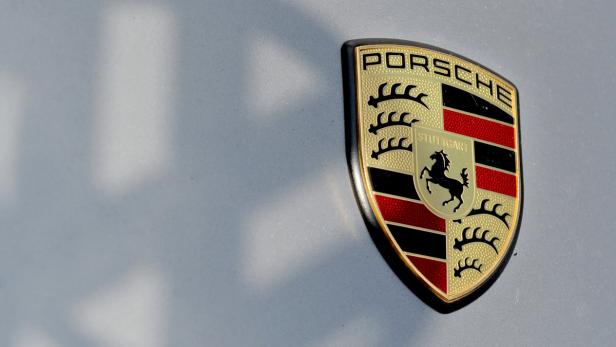 Das Porsche-Wappen auf einem grauen Hintergrund.