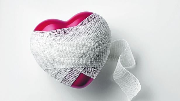 Ein rotes Herz ist mit einer weißen Bandage umwickelt.