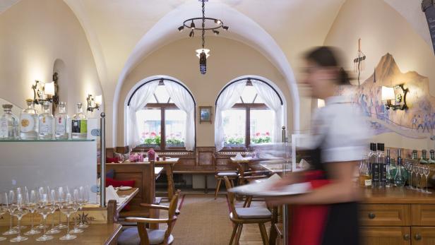 Ein Innenraum des Restaurants Döllerer mit einer Kellnerin im Vordergrund.