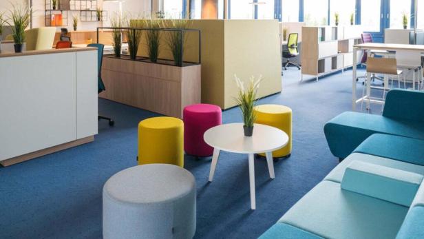 Ein modernes Büro mit farbenfrohen Sitzgelegenheiten und Pflanzen.