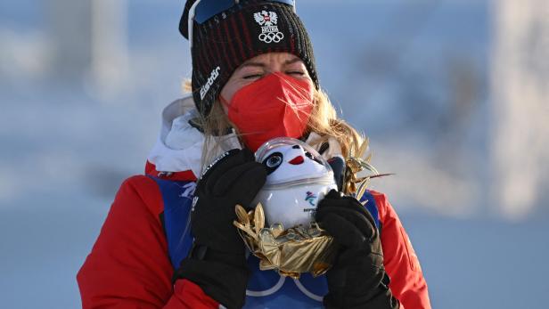 Therese Johaug umarmt ihr Maskottchen bei den Olympischen Winterspielen 2022 in Peking.