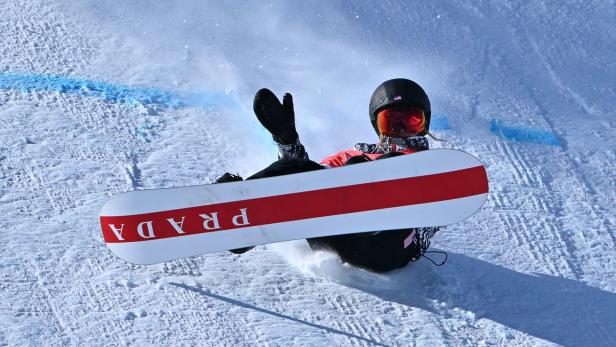 Eine Snowboarderin mit Prada-Snowboard auf einer schneebedeckten Piste.
