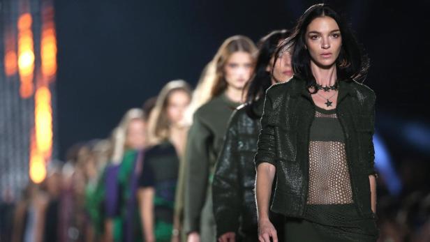 Eine Reihe von Models läuft bei einer Modenschau über den Laufsteg.