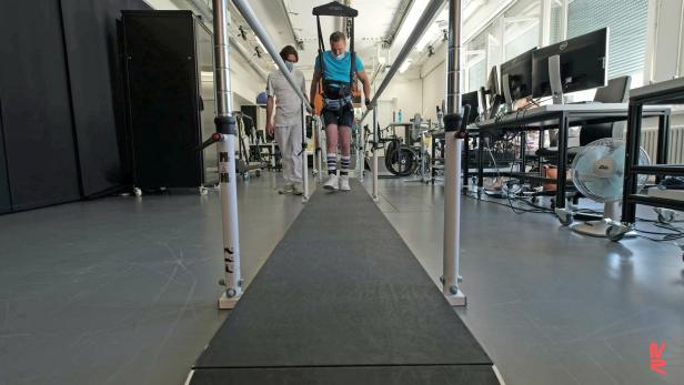 Patient performs training on a weight-supporting robot at Lausanne University after having received a spinal cord implant