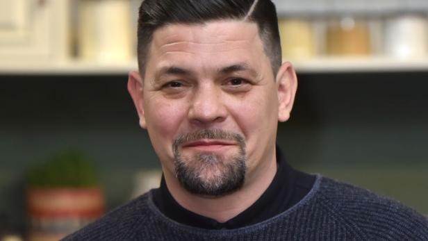 Ein Mann mit Bart und grauem Pullover blickt in die Kamera.