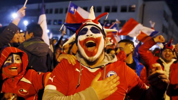 Chilenische Fans feiern mit Gesichtsbemalung und Flaggen.