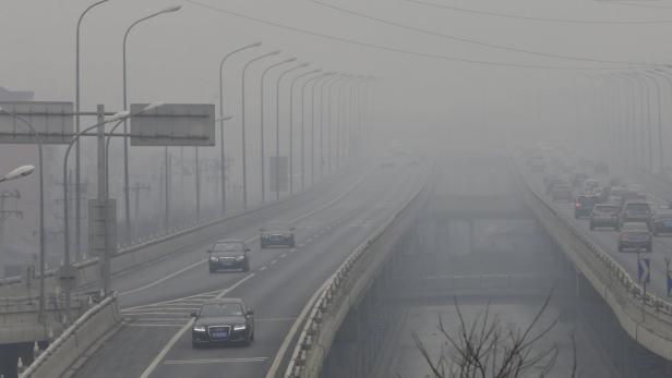 Autos fahren auf einer mehrspurigen Autobahn bei starkem Smog.