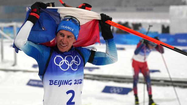 Ein Biathlet mit der französischen Flagge bei den Olympischen Spielen in Peking 2022.