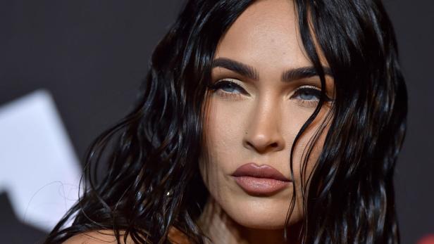 Nahaufnahme von Megan Fox mit gewelltem, dunklem Haar und hellem Make-up.