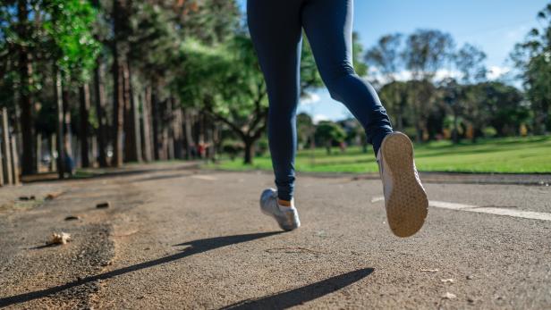 Eine Person joggt auf einem Weg in einem Park.