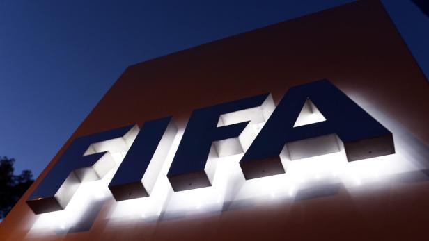Das beleuchtete FIFA-Logo an einem Gebäude bei Dämmerung.
