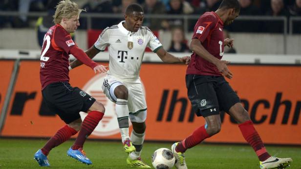 David Alaba (Bayern München) im Zweikampf mit zwei Spielern von Hannover 96.