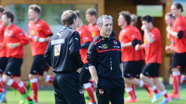Der österreichische Fußballtrainer steht vor einer Gruppe von Spielern beim Training.