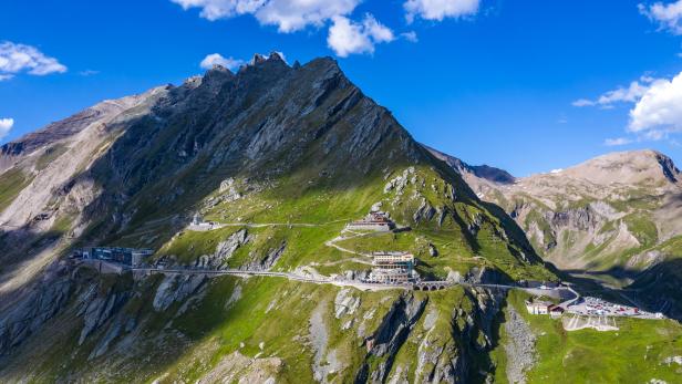 Die Großglockner Hochalpenstraße schlängelt sich durch eine grüne Berglandschaft.