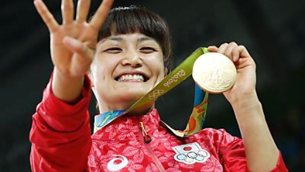 Eine japanische Judoka feiert mit ihrer Goldmedaille bei den Olympischen Spielen.