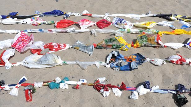 5000 Plastiksackerl miteinander verknotet, sollen einen Fisch darstellen. Guinness-Rekordaktion am Strand von Niendorf, Deutschland