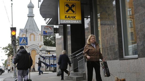 People walk near a branch office of Raiffeisen Bank in St. Petersburg