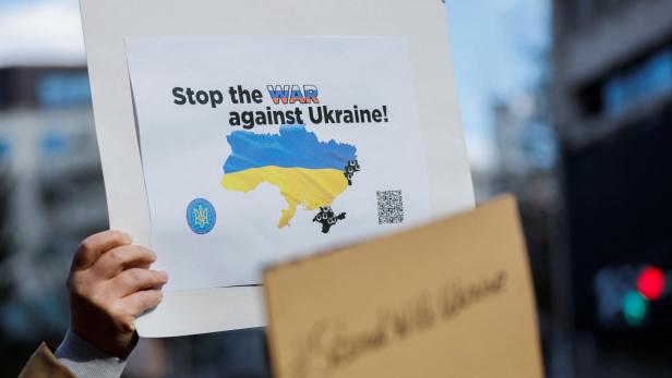 A Ukrainian residing in Japan shows a placard during a protest rally denouncing Russia over its actions in Ukraine, near Russian embassy in Tokyo