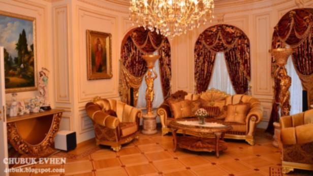 Ein opulent eingerichtetes Wohnzimmer mit goldenen Akzenten und einem Kristalllüster.