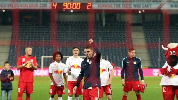 Fußballspieler von Red Bull Salzburg feiern auf dem Rasen, während die Anzeigetafel 4:2 anzeigt.