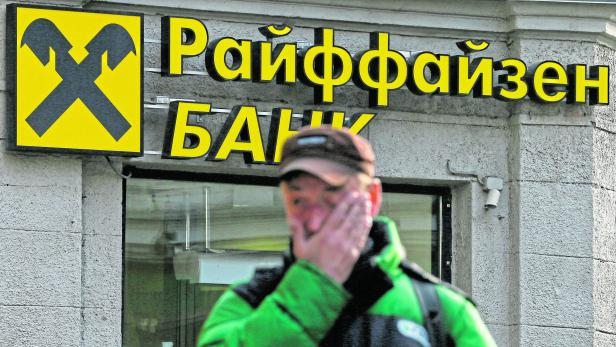A pedestrian walks past a branch office of Raiffeisen Bank in Moscow