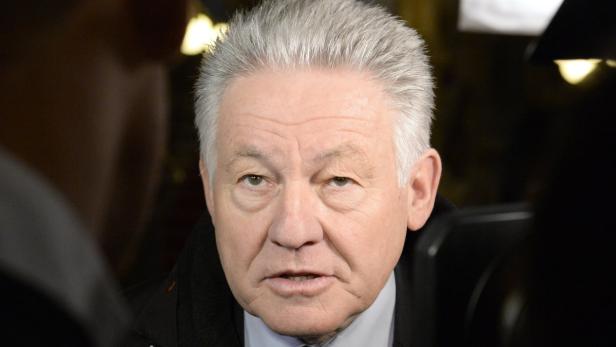 Ein älterer Mann mit grauem Haar schaut in die Kamera.