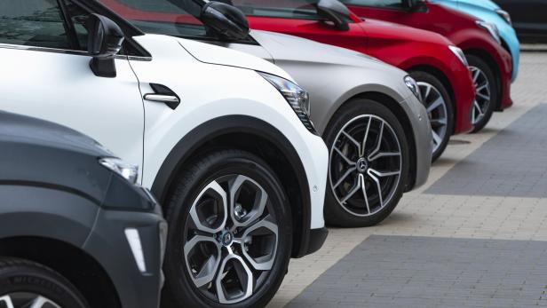 Mehrere Autos unterschiedlicher Farben stehen in einer Reihe geparkt.