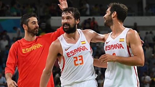 Drei spanische Basketballspieler feiern auf dem Spielfeld.