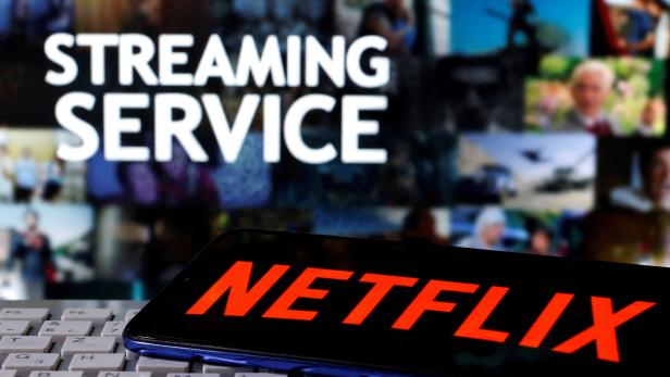 FILE PHOTO: FILE PHOTO: A smartphone with the Netflix logo is seen on a keyboard in front of displayed "Streaming service" words in this illustration