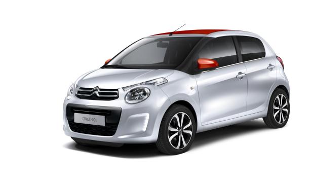 Ein silberner Citroën C1 mit rotem Dach und roten Spiegeln vor einem weißen Hintergrund.