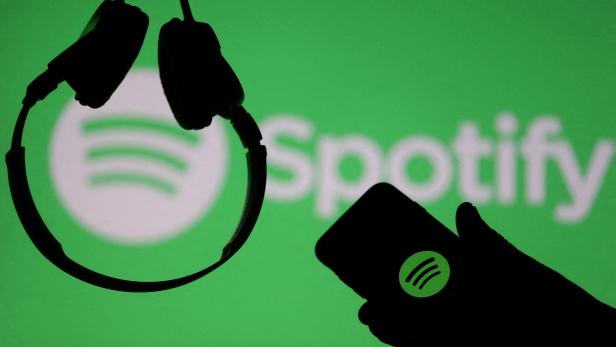 FILE PHOTO: A smartphone and a headset are seen in front of a screen projection of Spotify logo, in this picture illustration FILE PHOTO: A smartphone and a headset are seen in front of a screen projection of Spotify logo, in this picture illustration