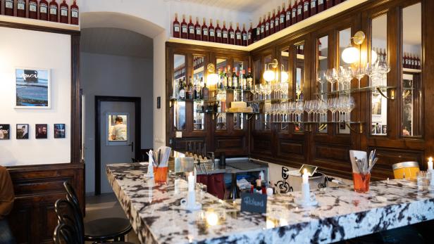 Innenansicht einer Bar mit Campari-Flaschen und einer Marmorbar.