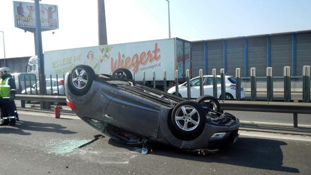 Ein Auto liegt nach einem Unfall auf der Autobahn auf dem Dach.